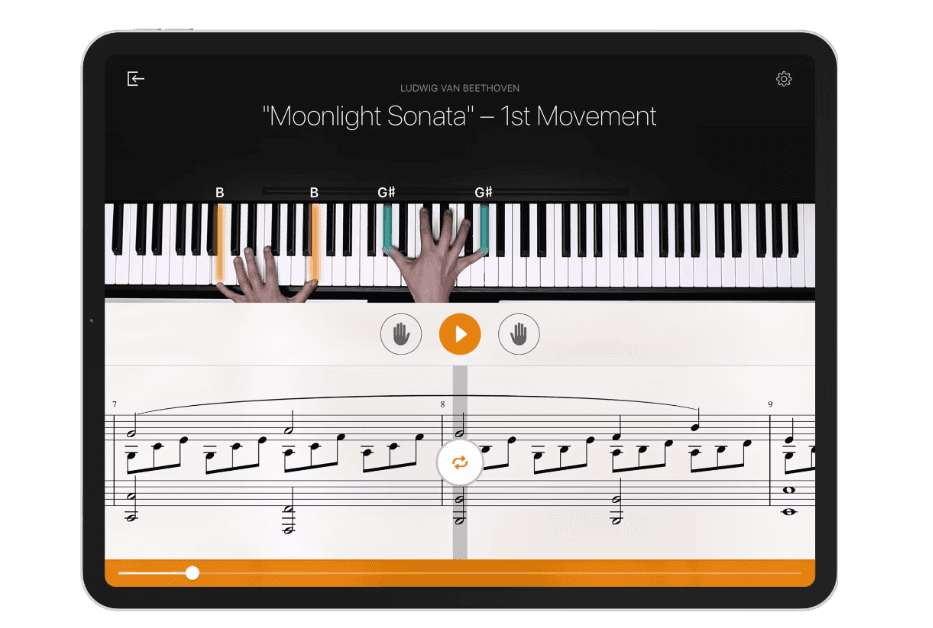 The flowkey app: the top half of the screen shows a pair of hands playing the piano and the bottom half the musical sheet